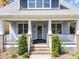 Inviting front porch with brick accents, white railings, and well-manicured landscaping at 1011 Parker St, Raleigh, NC 27607
