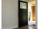 Modern front door with glass pane, opening to a bright foyer with hardwood floors at 1015 Washington St, Burlington, NC 27217