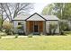 Charming home with white siding, a modern black front door, and a well-manicured lawn at 1015 Washington St, Burlington, NC 27217