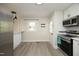 Bright kitchen boasts stainless steel appliances, white cabinetry, and light, wood-look flooring at 1015 Washington St, Burlington, NC 27217