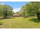 Expansive backyard featuring a fire pit, storage sheds, and mature trees at 1017 Southerlund Rd, Garner, NC 27529