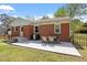Backyard patio with furniture and grill provides perfect relaxation space; brick home with white trim at 1017 Southerlund Rd, Garner, NC 27529