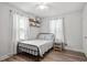 Serene bedroom with a metal-frame bed, minimalist decor, and ample natural light streaming through the windows at 1017 Southerlund Rd, Garner, NC 27529