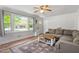 Bright living room with large windows, a cozy couch, and an area rug at 1017 Southerlund Rd, Garner, NC 27529