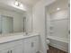 Bright bathroom featuring a white vanity with modern fixtures and a pristine shower-tub combination at 1028 Channel Drop Lp, Zebulon, NC 27597