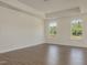 Spacious bedroom with wood-look floors, neutral paint, tray ceiling, and windows letting in lots of natural light at 1028 Channel Drop Lp, Zebulon, NC 27597
