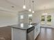 Bright kitchen features a large island with granite countertops, stainless steel appliances, and pendant lighting at 1028 Channel Drop Lp, Zebulon, NC 27597