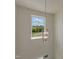 Stylish light fixture hanging in front of a window, offering a pleasant view of the outdoors and clear sky at 1028 Channel Drop Lp, Zebulon, NC 27597