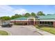 Exterior of Riverwood Athletic Club featuring brick accents, lush landscaping, and ample parking at 1053 Loop Rd, Clayton, NC 27527