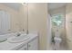 Bright bathroom with a white sink, large mirror, and window providing natural light at 1053 Loop Rd, Clayton, NC 27527