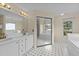 Spacious bathroom featuring dual vanities, tub, large mirrors, and a walk-in closet at 1053 Loop Rd, Clayton, NC 27527