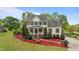 Charming yellow two-story home with green shutters and a beautifully landscaped front yard at 1053 Loop Rd, Clayton, NC 27527