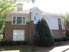 Brick townhome featuring multiple windows, neutral siding, landscaped lawn, and a covered entrance at 1062 Washington St # 201, Raleigh, NC 27605