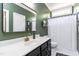 Stylish bathroom featuring a large mirror, vanity, and shower with white curtain at 10709 Thornbury Crest Ct, Raleigh, NC 27614