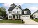 Beautiful two-story home with a white brick exterior, dark shutters and a well-manicured front yard at 10709 Thornbury Crest Ct, Raleigh, NC 27614
