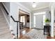 Bright foyer with staircase, hardwood floors, decorative rug, and view into the dining room at 10709 Thornbury Crest Ct, Raleigh, NC 27614