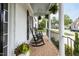 Inviting covered porch with rocking chairs, potted plants, and brick flooring, perfect for relaxing outdoors at 10709 Thornbury Crest Ct, Raleigh, NC 27614