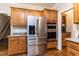 Gourmet kitchen showcasing stainless steel refrigerator, built-in oven, and custom wood cabinetry at 10709 Thornbury Crest Ct, Raleigh, NC 27614