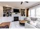 Comfortable living room featuring a fireplace with built-in shelving, natural light, and cozy furniture at 10709 Thornbury Crest Ct, Raleigh, NC 27614