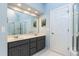 Bright bathroom featuring double sink vanity, large mirror, and a separate shower area at 10709 Thornbury Crest Ct, Raleigh, NC 27614