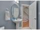 Well-lit powder room with pedestal sink, oval mirror, and tiled floor at 109 Jones Creek Pl, Chapel Hill, NC 27516