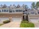 Charming townhome showcasing brick facade, dormer windows, and attached garages at 109 Jones Creek Pl, Chapel Hill, NC 27516
