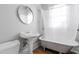 Charming bathroom with a vintage-style clawfoot tub, pedestal sink, and a wall mirror at 1105 W Lenoir St, Raleigh, NC 27603