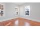 Sunlit bedroom with hardwood floors and three large windows, offering ample natural light at 1105 W Lenoir St, Raleigh, NC 27603