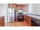 Efficient kitchen with stainless steel refrigerator, wood cabinets, gas range, and tiled backsplash at 1105 W Lenoir St, Raleigh, NC 27603