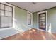 Cozy covered front porch with black door, wood floors, and lots of natural light at 1105 W Lenoir St, Raleigh, NC 27603