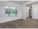 Bright living room featuring a large window and stylish wood-look flooring at 11430 International Dr, Middlesex, NC 27557