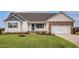 Charming single-story home boasts stone accents, an attached garage, and a well-manicured front lawn at 11682 International Dr, Middlesex, NC 27557