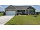 Inviting single-story home boasts a well-maintained lawn, two car garage and stone and gray vinyl siding at 11682 International Dr, Middlesex, NC 27557