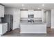Modern kitchen featuring stainless steel appliances, white cabinetry, granite countertops and gray wood-look floors at 11682 International Dr, Middlesex, NC 27557