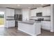Modern kitchen featuring white cabinets, stainless steel appliances, and an island with granite countertops at 11682 International Dr, Middlesex, NC 27557