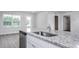 Bright kitchen island featuring a stainless steel sink, granite countertops, and white cabinetry at 11682 International Dr, Middlesex, NC 27557