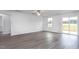 Open living area featuring a ceiling fan, sliding door to a deck, and neutral walls with gray wood-look flooring at 11682 International Dr, Middlesex, NC 27557