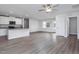 Bright living room featuring grey hardwood floors, a ceiling fan, and a kitchen with granite countertops at 11682 International Dr, Middlesex, NC 27557