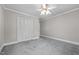 This bedroom features neutral walls, carpet flooring, closet space, and a ceiling fan at 118 Shannon Dr, Burlington, NC 27215