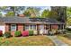 Charming red brick home with black shutters, gray roof, and colorful landscaped front yard at 118 Shannon Dr, Burlington, NC 27215