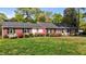 Charming one-story brick home with black shutters and colorful azaleas in the front yard at 118 Shannon Dr, Burlington, NC 27215
