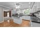 Bright kitchen with white cabinets, wood flooring, an island, and access to the living room at 118 Shannon Dr, Burlington, NC 27215