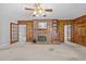 Living room features a brick fireplace, built-in shelves, wood paneling, and access to sunroom at 118 Shannon Dr, Burlington, NC 27215