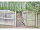 Wooden fence with an arched gate opening to a wooded area in a spacious backyard at 1201 Bellenden Dr, Durham, NC 27713