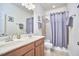 Bathroom features double sinks, warm wood cabinets, brushed chrome hardware, and large mirror at 1201 Bellenden Dr, Durham, NC 27713