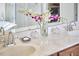 Marble top vanity with double sinks, flowers, decorative orbs and brushed chrome faucets at 1201 Bellenden Dr, Durham, NC 27713
