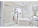 Bright bathroom featuring a tiled shower with glass door and corner bathtub at 1201 Bellenden Dr, Durham, NC 27713