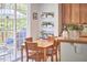 Bright dining area with access to a deck, featuring a wooden table and chairs, cabinets and plant decor at 1201 Bellenden Dr, Durham, NC 27713
