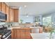 Cozy kitchen with stainless steel appliances, wooden cabinets, countertop seating, and view into the living room at 1201 Bellenden Dr, Durham, NC 27713