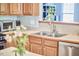 Well-lit kitchen features stainless steel appliances, double sink, wooden cabinets, and view into an adjacent room at 1201 Bellenden Dr, Durham, NC 27713